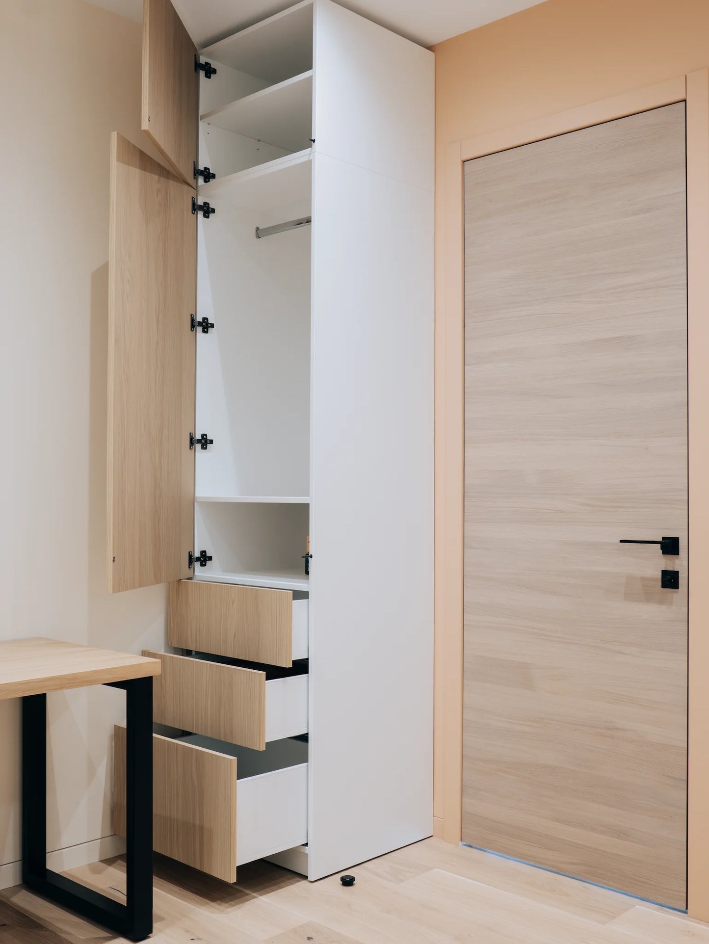 Modern wardrobe with wooden doors and drawers in a minimalistic room.