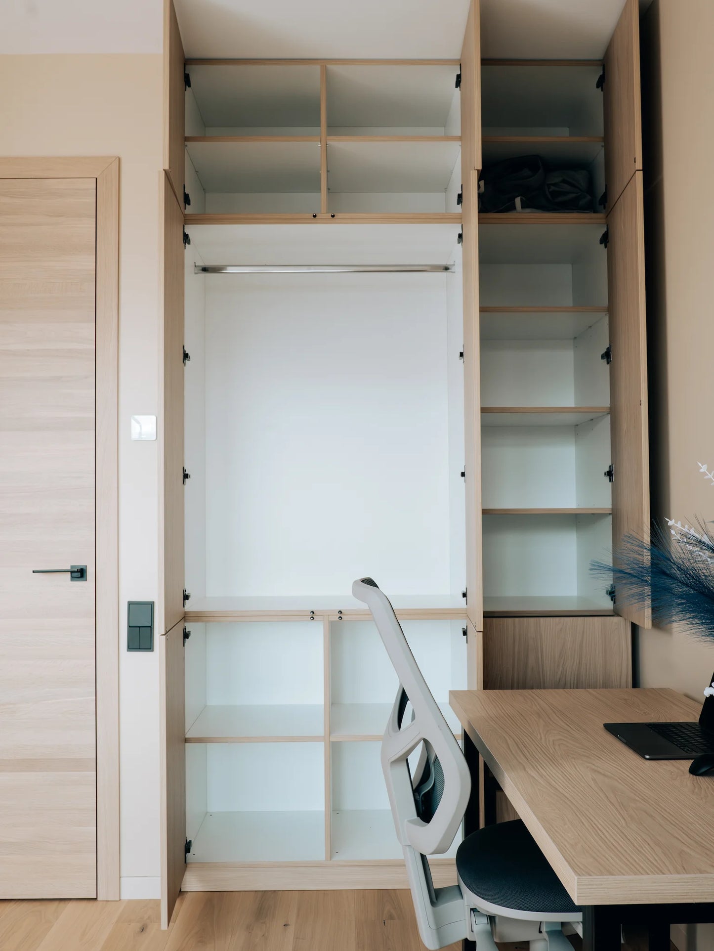 Wooden study nook with desk, chair, and open shelves.