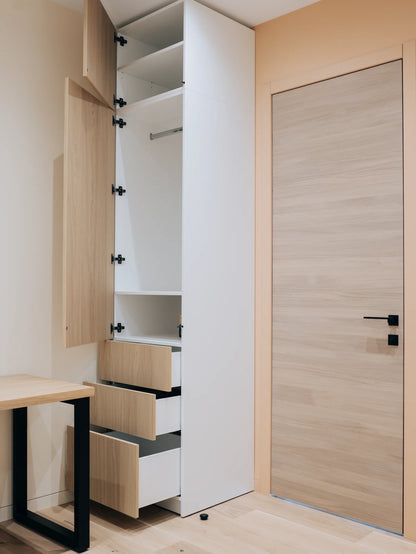 Modern wardrobe with wooden doors and drawers in a minimalistic room.