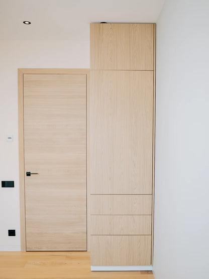 Wooden door and wardrobe against a white wall