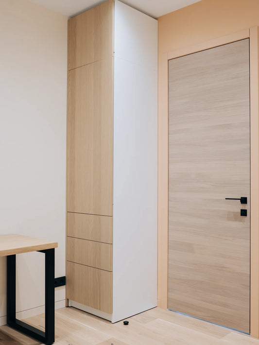 Wooden wardrobe and door in a room with a table.