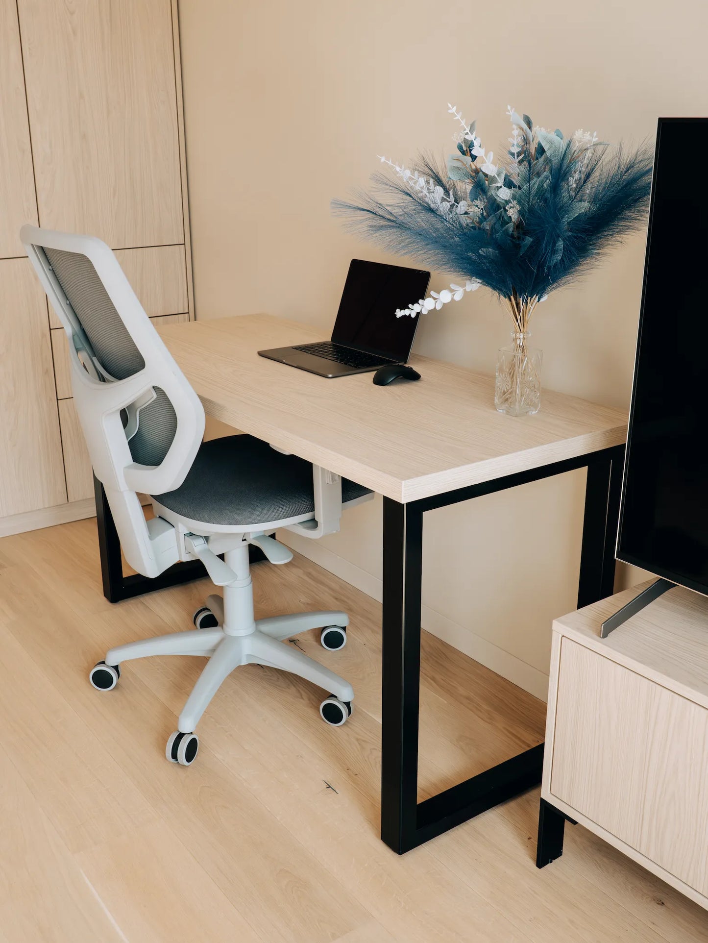 Modern office setup with a desk, chair, laptop, and decorative elements.