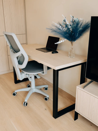 Modern office setup with a desk, chair, laptop, and decorative elements.