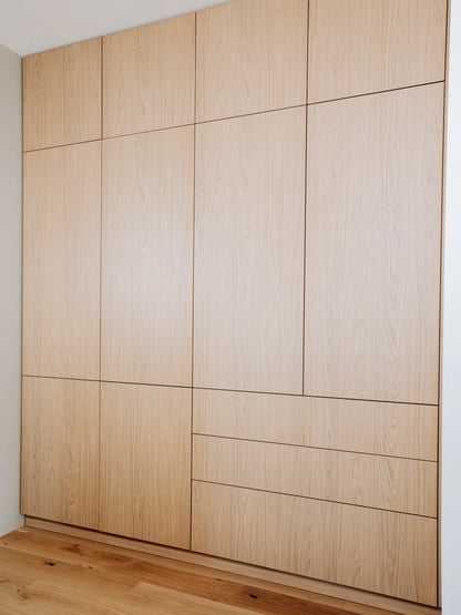 Wooden wardrobe with a grid pattern on a white wall.