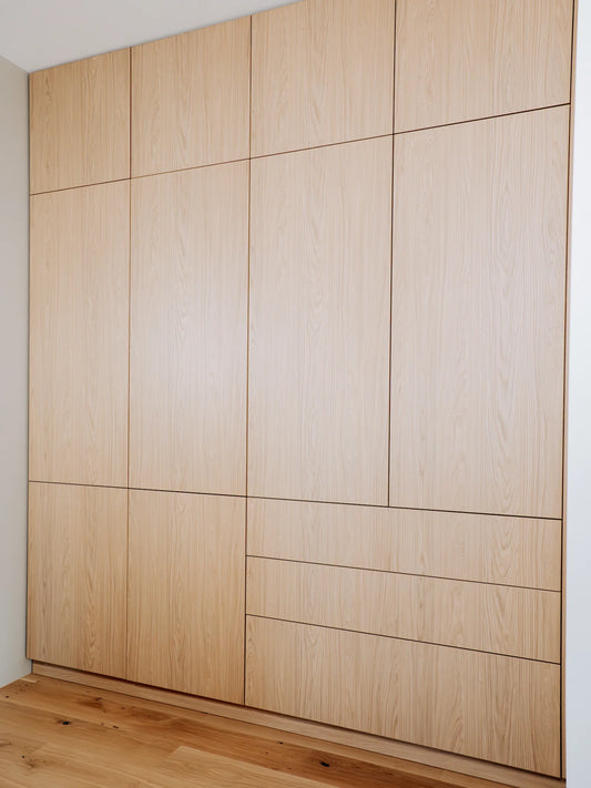 Wooden wardrobe with a grid pattern on a white wall.