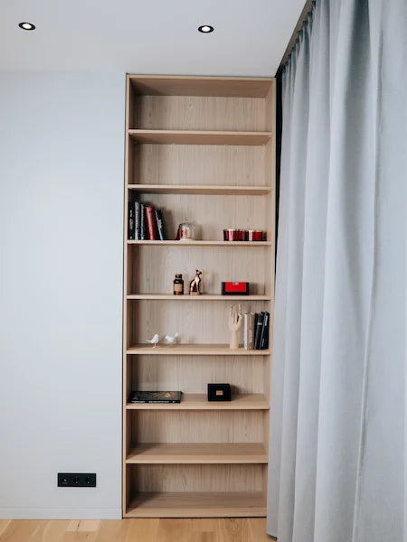 Wooden bookshelf with decorative items against a white wall