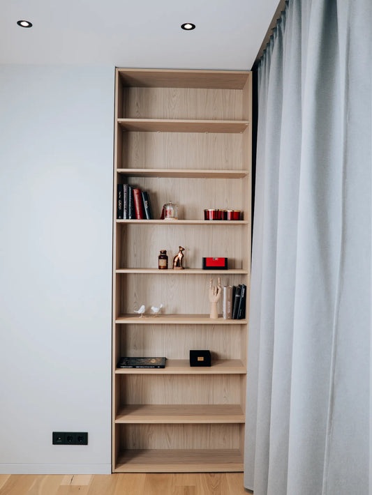 Wooden bookshelf with decorative items against a white wall