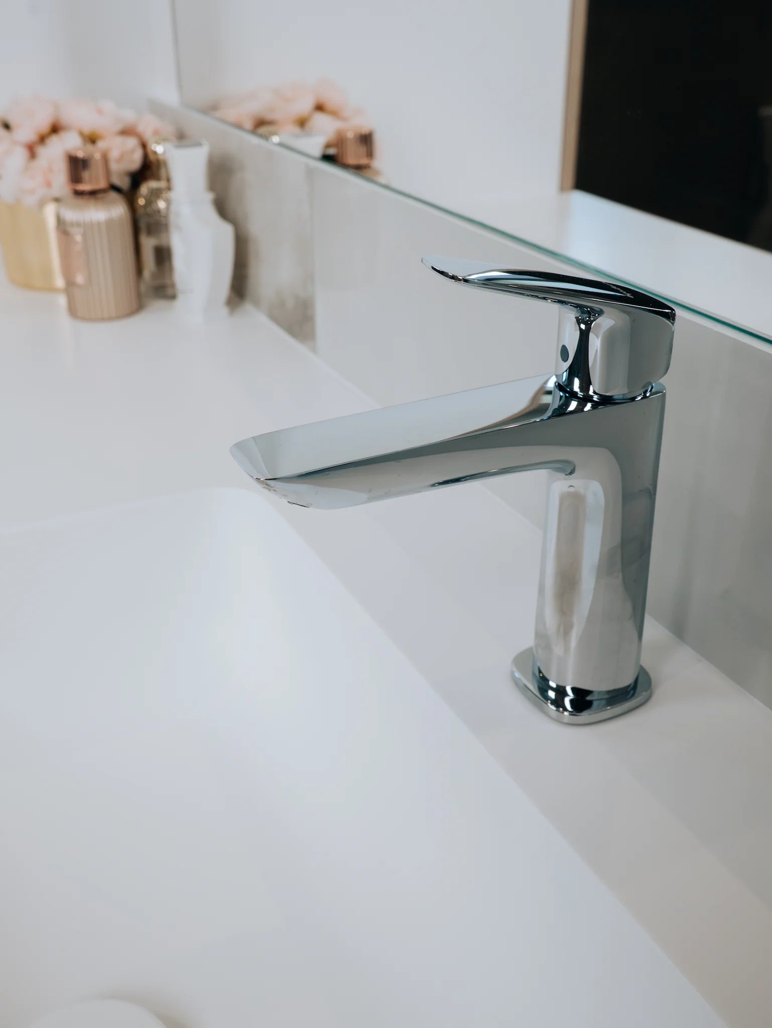 Chrome faucet on a white sink with a blurred background