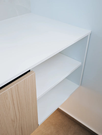 White desk with wooden side panel and chair in a minimalistic room.